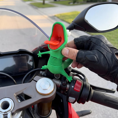 Rider pressing the green lizard figure onto a motorcycle next to the handlebar